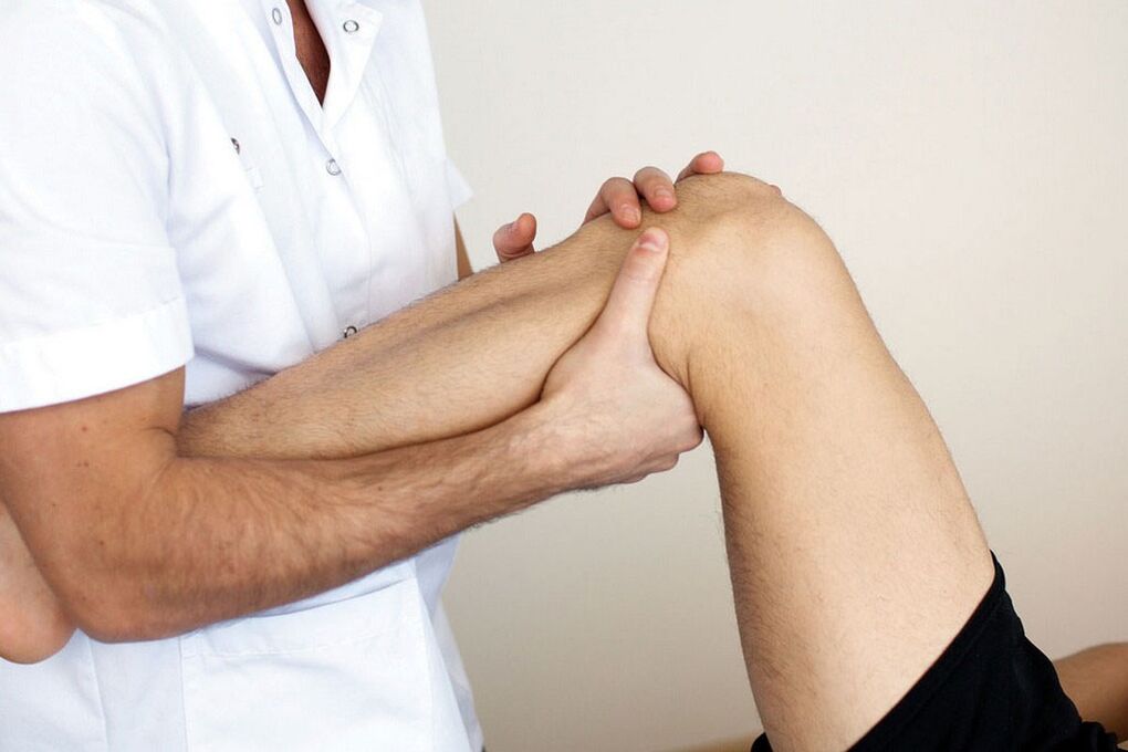 the doctor examines the knee with osteoarthritis